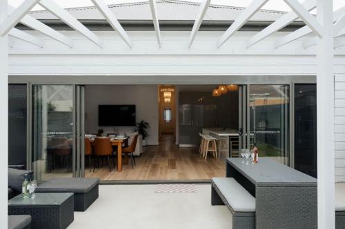 a living room with a patio with tables and chairs at Vida Hamilton - 3 bed, 2 bath kids playground! in Hamilton