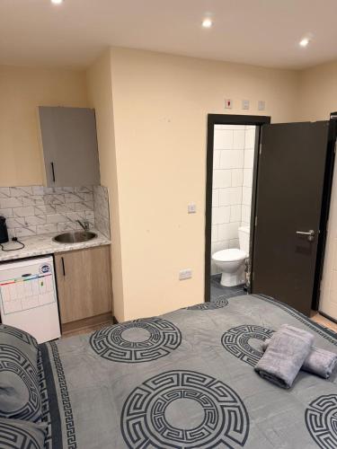 a bathroom with a bed and a sink and a toilet at Modern Studios Epsom Station in Epsom