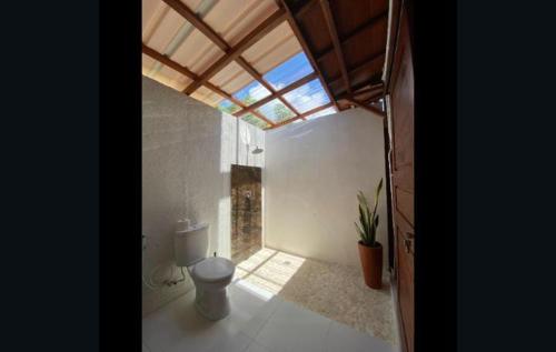 a bathroom with a toilet in a room with a window at Kahurangi Hotel in Sekongkang