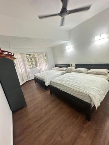 two beds in a room with wooden floors at Fraser's Haven SilverparkResort Walk down 8 steps in Bukit Fraser