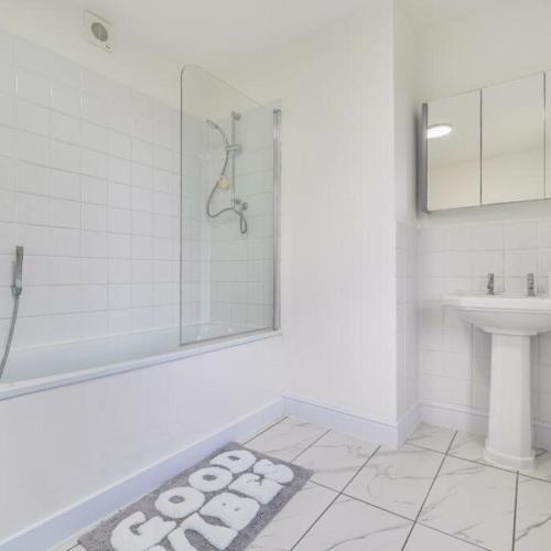 a white bathroom with a shower and a sink at Spacious 3 Bedroom Property, Sleeps 8, Perfect for Business & Leisure in South East London in London