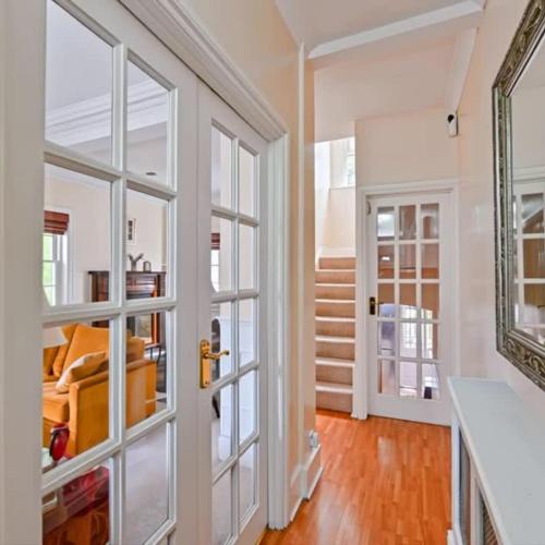 a hallway with glass doors and a staircase at Spacious 3 Bedroom Property, Sleeps 8, Perfect for Business & Leisure in South East London in London