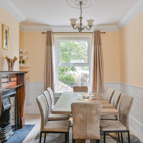 a dining room with a table and chairs and a window at Spacious 3 Bedroom Property, Sleeps 8, Perfect for Business & Leisure in South East London in London