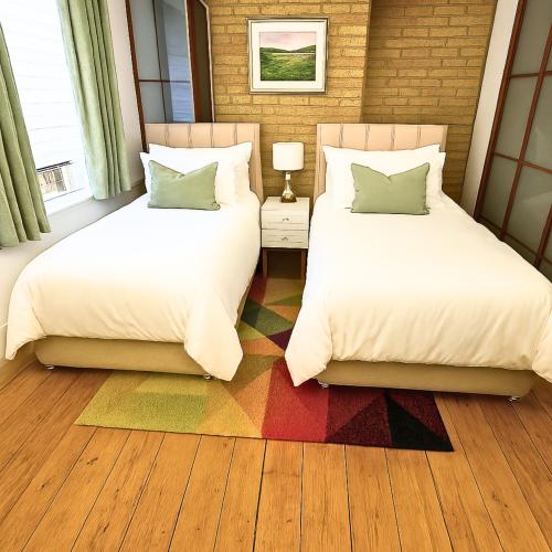 two beds sitting in a room with ainylinylinylinylinylinylinylinyl at Spacious 3 Bedroom Property, Sleeps 8, Perfect for Business & Leisure in South East London in London