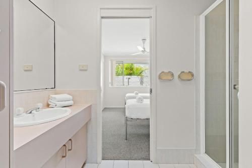 a white bathroom with a sink and a mirror at Ballina Golf Unit in East Ballina