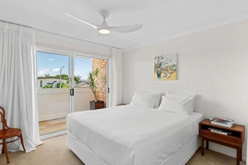 a white bedroom with a white bed and a window at Sun Soaked Lennox Village in Lennox Head