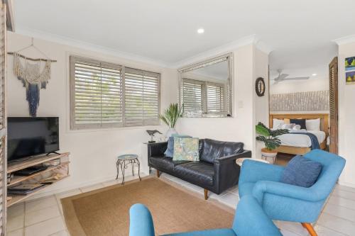 a living room with a couch and a tv at Barefoot in Lennox in Lennox Head