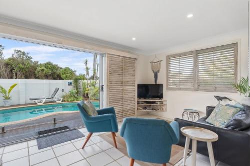 a living room with a couch and a pool at Barefoot in Lennox in Lennox Head