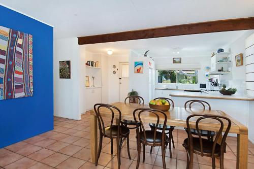 a kitchen and dining room with a wooden table and chairs at Beach House in Lennox Head