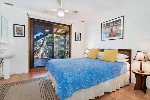 a bedroom with a bed and a window and a sink at Beach House in Lennox Head