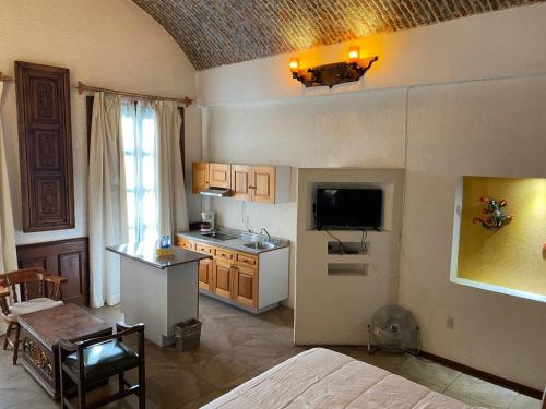 a room with a bed and a kitchen with a television at Suite vista hermosa in San Miguel de Allende