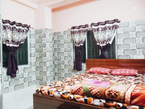 a bedroom with a bed with a brick wall at Rukmini Guest House in Kolkata