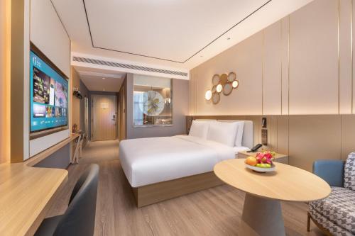 a hotel room with a bed and a table at Orange Hotel Kunshan MixC Hotel in Kunshan