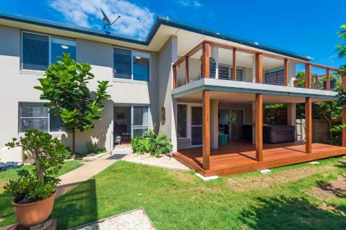 a house with a large deck in a yard at Beach Views in Lennox Head