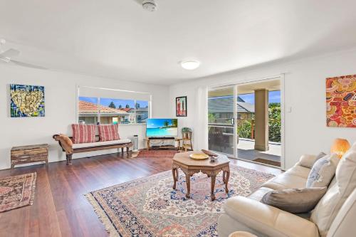 a living room with a couch and a table at Beach Views in Lennox Head