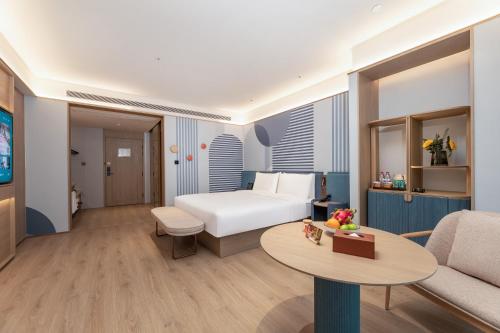 a hotel room with a bed and a table at Orange Hotel Kunshan MixC Hotel in Kunshan