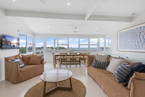 a living room with couches and a dining room with a table at Walters in East Ballina