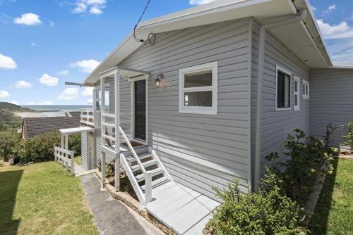 a tiny house with a porch and a staircase at Walters in East Ballina