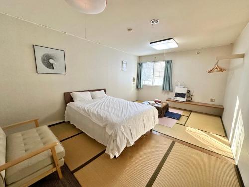 a bedroom with a bed and a chair in it at 北志賀ライムライト in Shimotakai