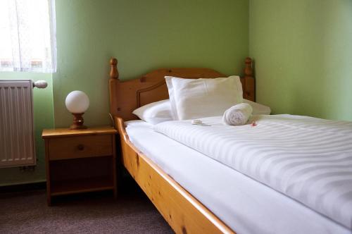 a bedroom with a bed with a white bedspread and a pillow at Penzion Diana in Teplice nad Bečvou