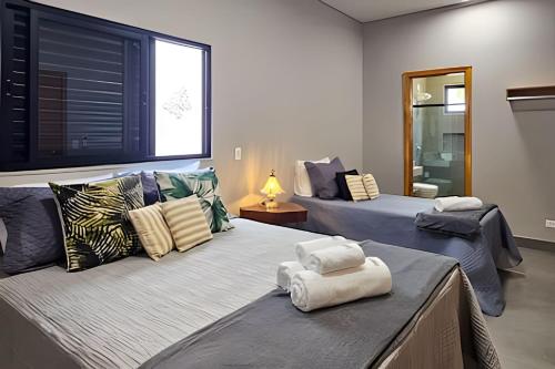 a bedroom with two beds with pillows on them at Casa Ninhal, super central, nova e espaçosa. in Bonito
