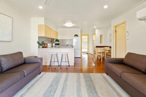 a living room with two couches and a kitchen at Haere Mai 2 in East Ballina