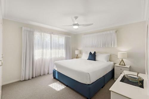 a bedroom with a large bed and a window at Hereford Court East Ballina in East Ballina