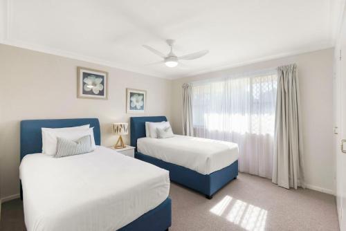 a bedroom with two beds and a window at Hereford Court East Ballina in East Ballina