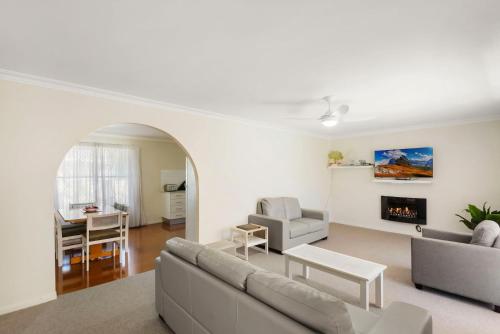 a living room with a couch and a fireplace at Hereford Court East Ballina in East Ballina