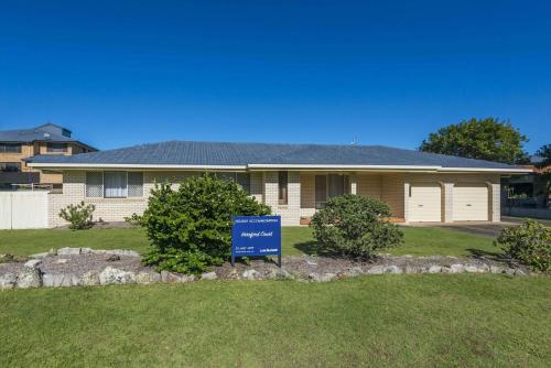 a house with a blue sign in front of it at Hereford Court East Ballina in East Ballina