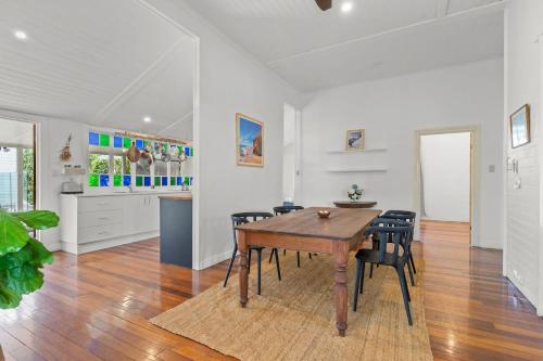 a kitchen and dining room with a wooden table and chairs at Hinterland Views in Lennox Head