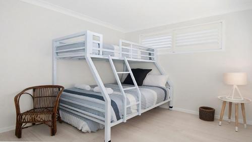 a white bunk bed in a white room with a chair at Kay s Hideaway in Lennox Head