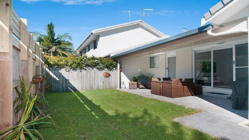 a backyard of a house with a grass yard at Kay s Hideaway in Lennox Head