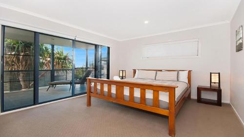 a bedroom with a bed and a balcony at KK s in Lennox Head in Lennox Head