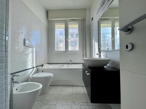 a bathroom with a tub and a toilet and a sink at Charming beach front apartment in Viareggio