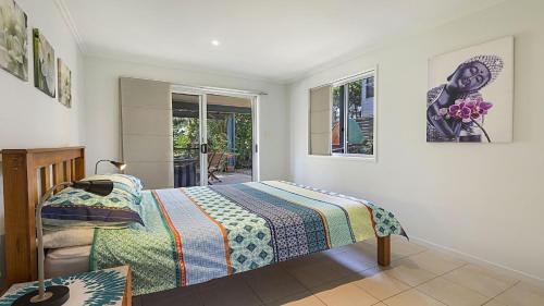 a bedroom with a bed and a window at Moana Retreat in Lennox Head