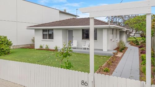 a white house with a white fence at Lennox Beach Shack in Lennox Head