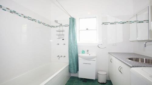 a white bathroom with a sink and a tub at My Blue Heaven Dog Friendly in Lennox Head