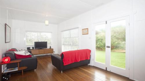 a living room with a couch and a television at My Blue Heaven Dog Friendly in Lennox Head