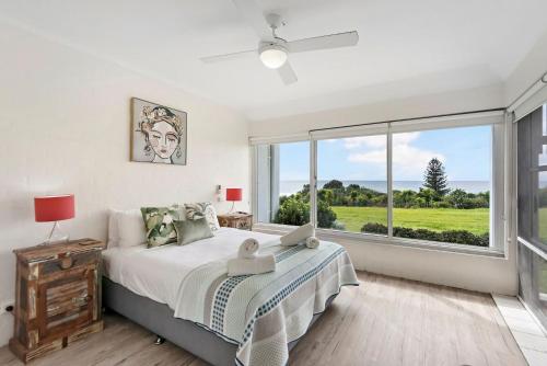 a bedroom with a bed and a large window at Quarterdeck 18 in Lennox Head