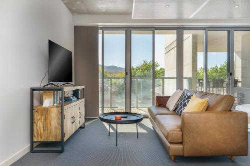 a living room with a couch and a tv at Spacious Studio in a Prime Braddon Location - Hosted by Canstay in Braddon