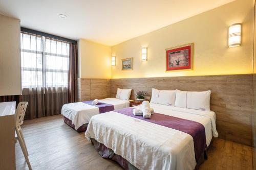 a hotel room with two beds in a room at Lavender Inn Permas Jaya in Johor Bahru