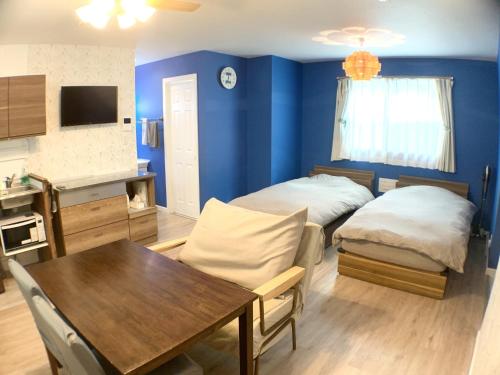 a living room with two beds and a dining room table at Alaula - Vacation STAY 22838v in Izumi-Sano