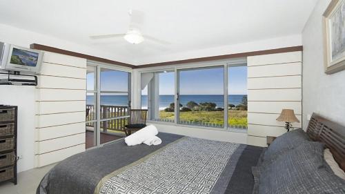 a bedroom with a bed with a view of the ocean at Quarterdeck 23 in Lennox Head
