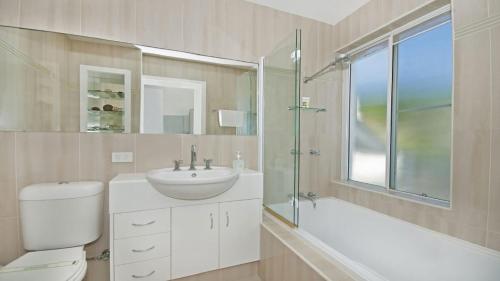 a bathroom with a toilet and a sink and a shower at Quarterdeck 23 in Lennox Head