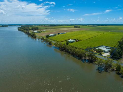 an aerial view of a river with green fields and houses at Robins Place in Empire Vale