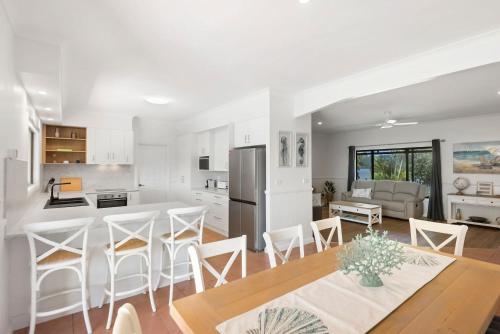 a kitchen and living room with a table and chairs at Robins Place in Empire Vale