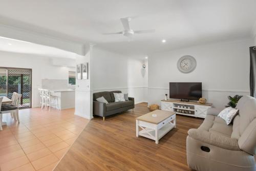 a living room with a couch and a tv at Robins Place in Empire Vale