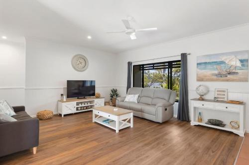 a living room with a couch and a tv at Robins Place in Empire Vale