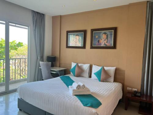 a bedroom with a bed with towels on it at Korapura Resort in Nakhon Ratchasima
